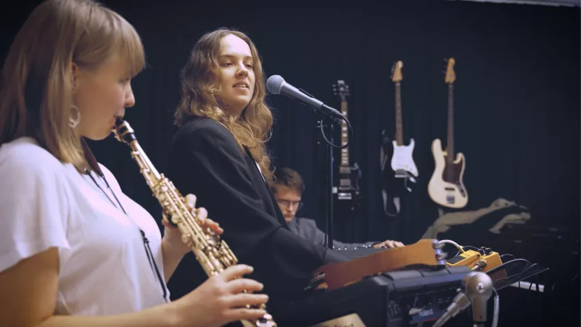 Three students jamming together. Photo.